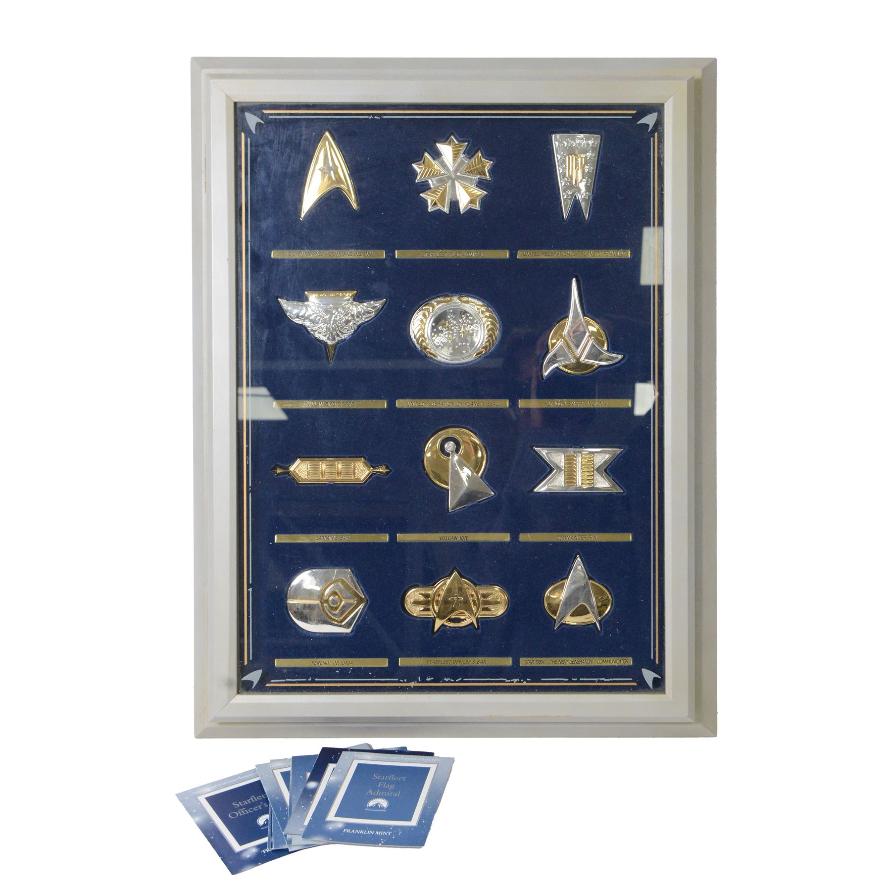 Franklin Mint The Official Star Trek Insignia Collection, set of twelve sterling silver insignia with gold plated decoration, all stamped 925 sterling with certificates of authenticity, contained within a wooden glazed display case, case H56cm