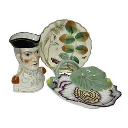 Chelsea style dish moulded as a large flower head with green stalk handle and two leaves with red anchor mark beneath, 19th century Staffordshire character jug modelled as the Duke of Wellington in military uniform, and a late Chamberlain plate