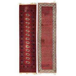  Persian design red ground runner, the field decorated with repeating Boteh motifs, five-band border (277cm x 74cm); Bokhara design red ground rug, decorated with a single row of Gul motifs (272cm x 69cm)