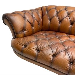 Tetrad - 'Oskar' grande three-seat sofa, Chesterfield shape with rolled arms, upholstered in buttoned tan leather, on turned and reed moulded feet 