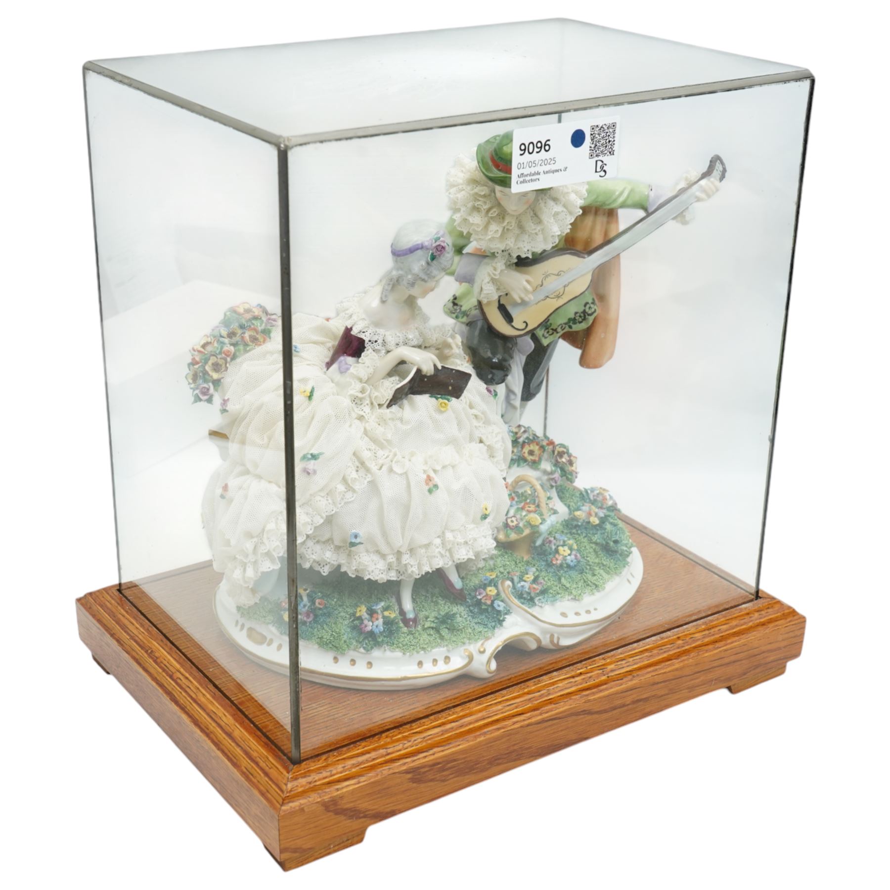 Unterweissbach style porcelain figural group of a seated lady with a gentleman playing a lute, stamped 'Foreign' to base, in bespoke display case