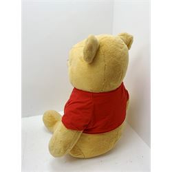Very large plush covered figure of Winnie The Pooh in a seated position with black plastic eyes, black felt nose and eyebrows, red open mouth and T-shirt with name to front H42