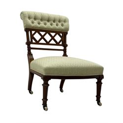 Late Victorian upholstered armchair, with high camel back and deep seat, padded arms and backrest in crimson and cream damask-style fabric, raised on turned ebonised front supports with ceramic castors (H88cm, W65cm, D 60m); and an Edwardian bedroom chair with button upholstered rail back (H72cm, D64cm, W53cm) (2)