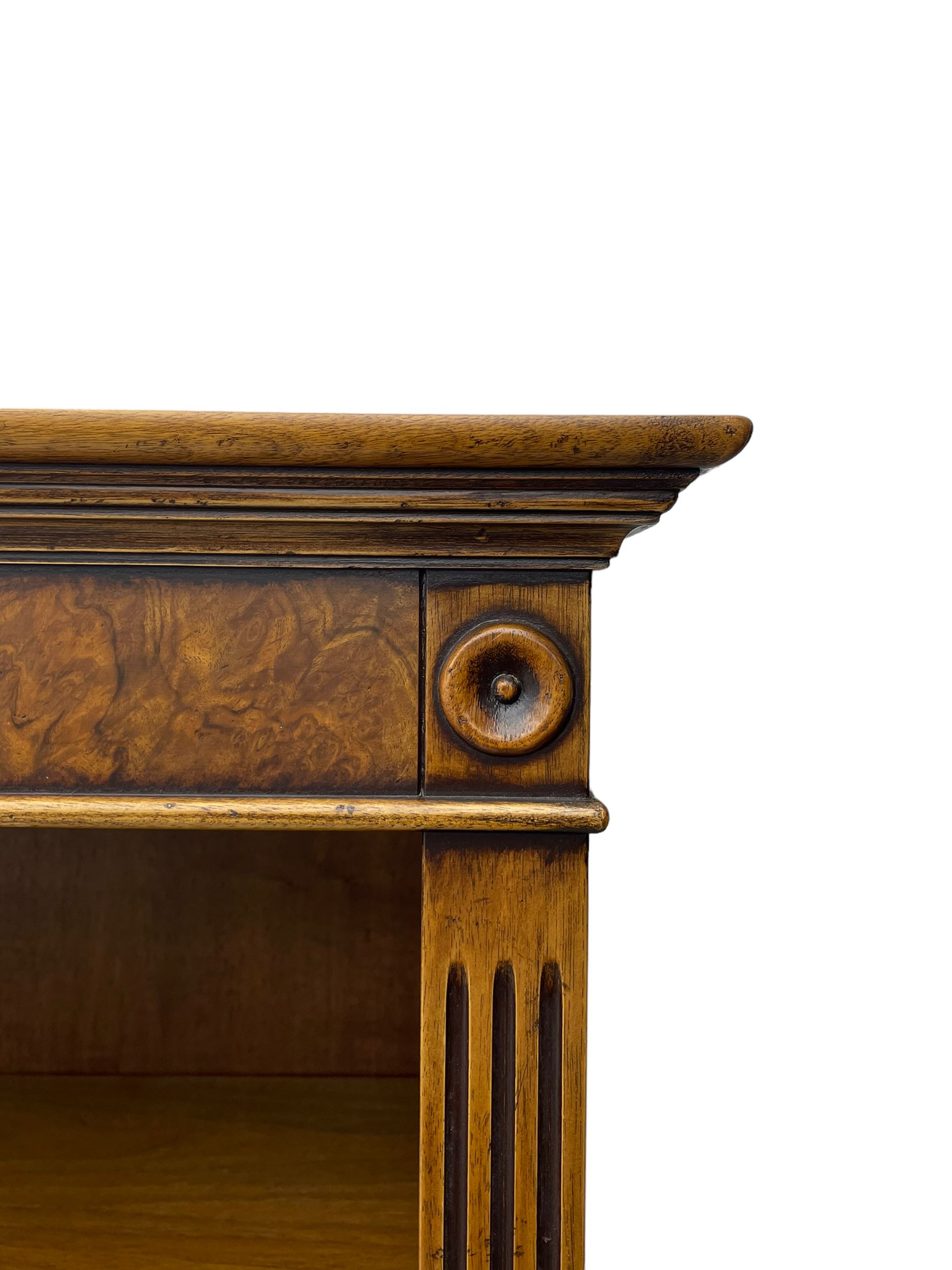 Georgian design walnut open bookcase, projecting cornice over figured banded frieze flanked by roundels, fitted with six adjustable shelves with flanking fluted uprights, on skirted base