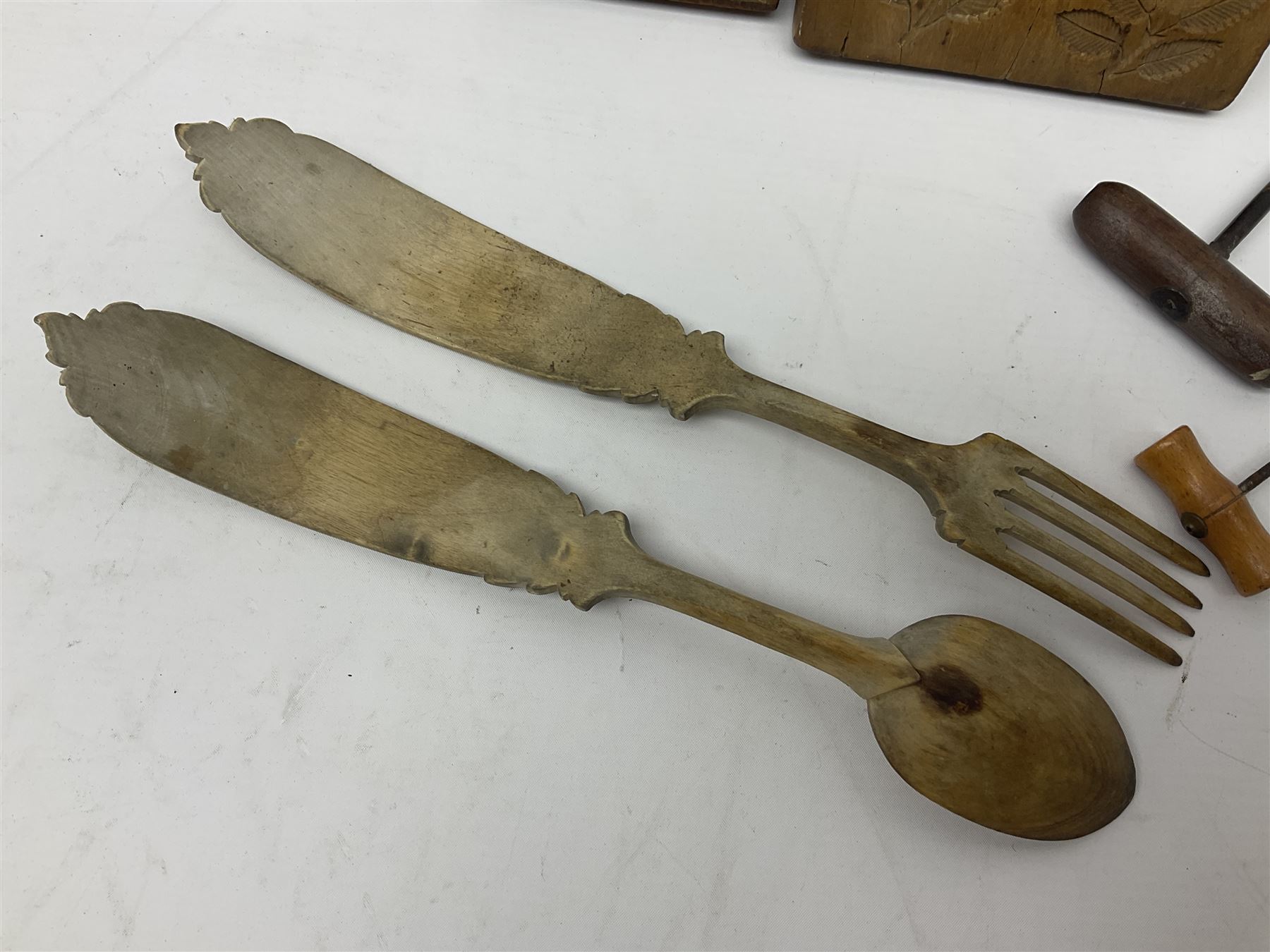 Two wooden biscuit moulds, carved loving spoon and fork, and two bradawls 