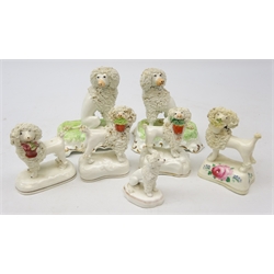  Pair Victorian Staffordshire seated Poodles on shaped base, H12cm, four Victorian Poodles stood holding baskets of flowers in their mouths and a miniature Poodle (7)  