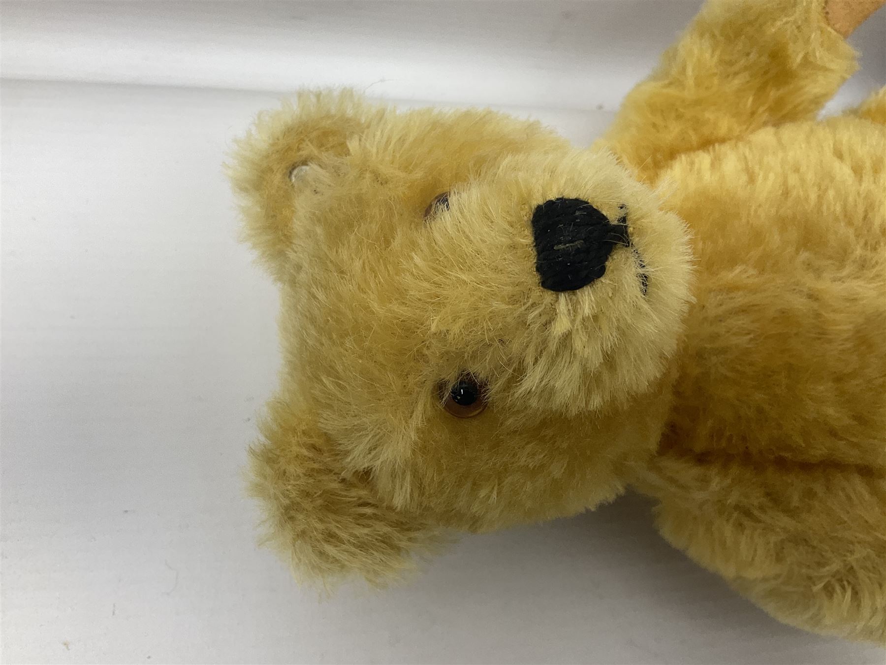 Steiff teddy bear with golden plush body, revolving head, applied eyes, vertically stitched nose and mouth and jointed limbs; button to left ear H26cm; and two other Steiff teddy bears, each with open mouth and button with tag to left ear (3)
