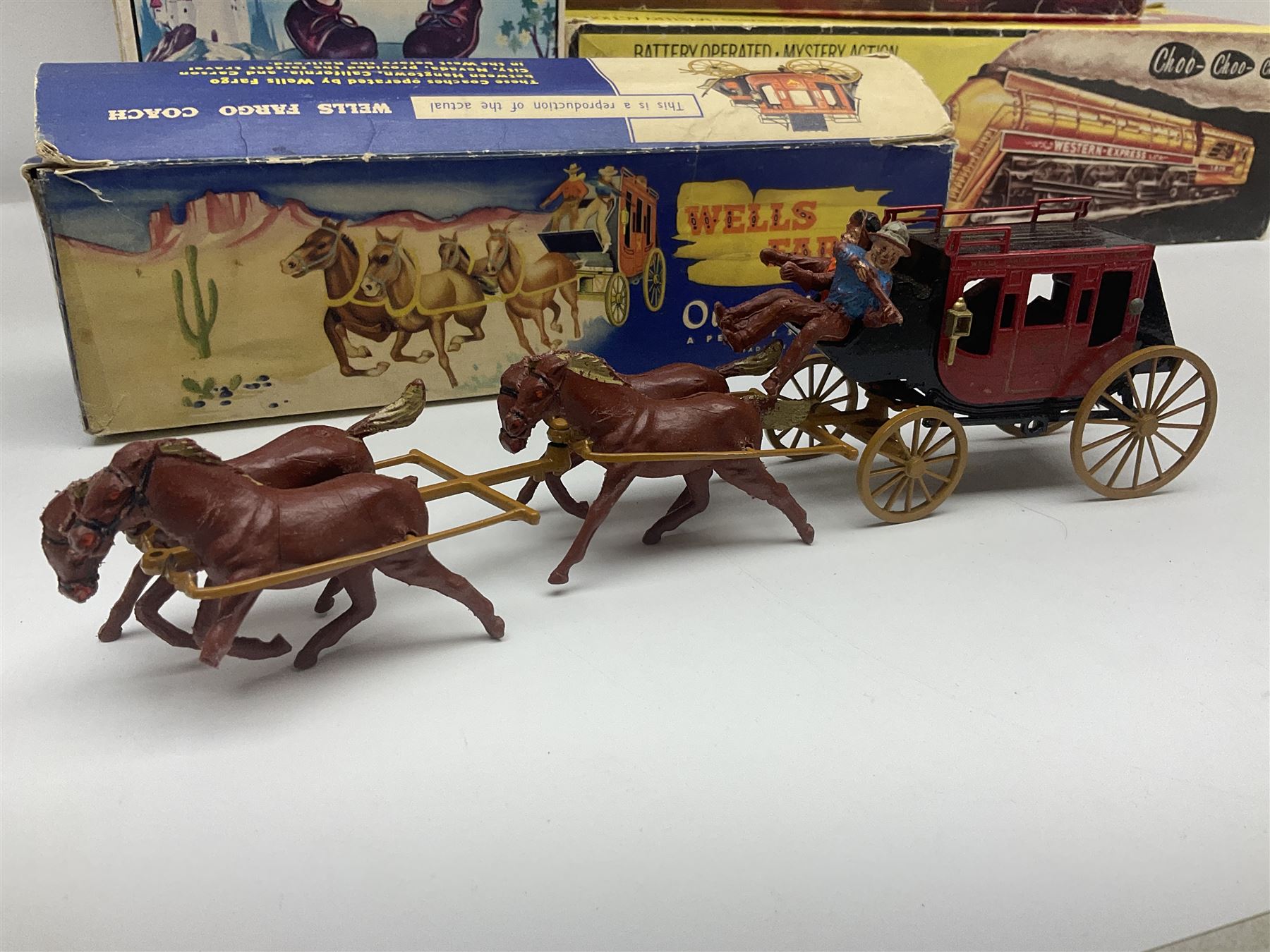 Mickey Mouse Trick Star battery operated drummer figure; Illco Mickey Mouse battery operated Fun Castle Roller Coaster; battery operated Western Express Locomotive; and JK Wells Fargo Overland Stage scale model; all boxed (4)