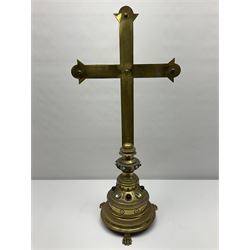 Brass alter cross, decorated with glass cabochons, upon a acicular stepped base and three claw feet, H73cm 