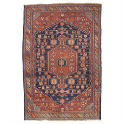 Persian Heriz hand-knotted carpet, terracotta ground centred by large dark navy geometric ...