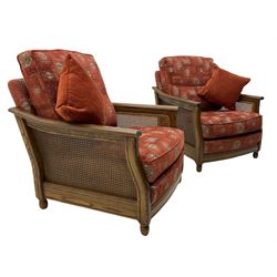 Ercol medium elm framed three seat bergere sofa, and pair of matching armchairs upholstered in red fabric