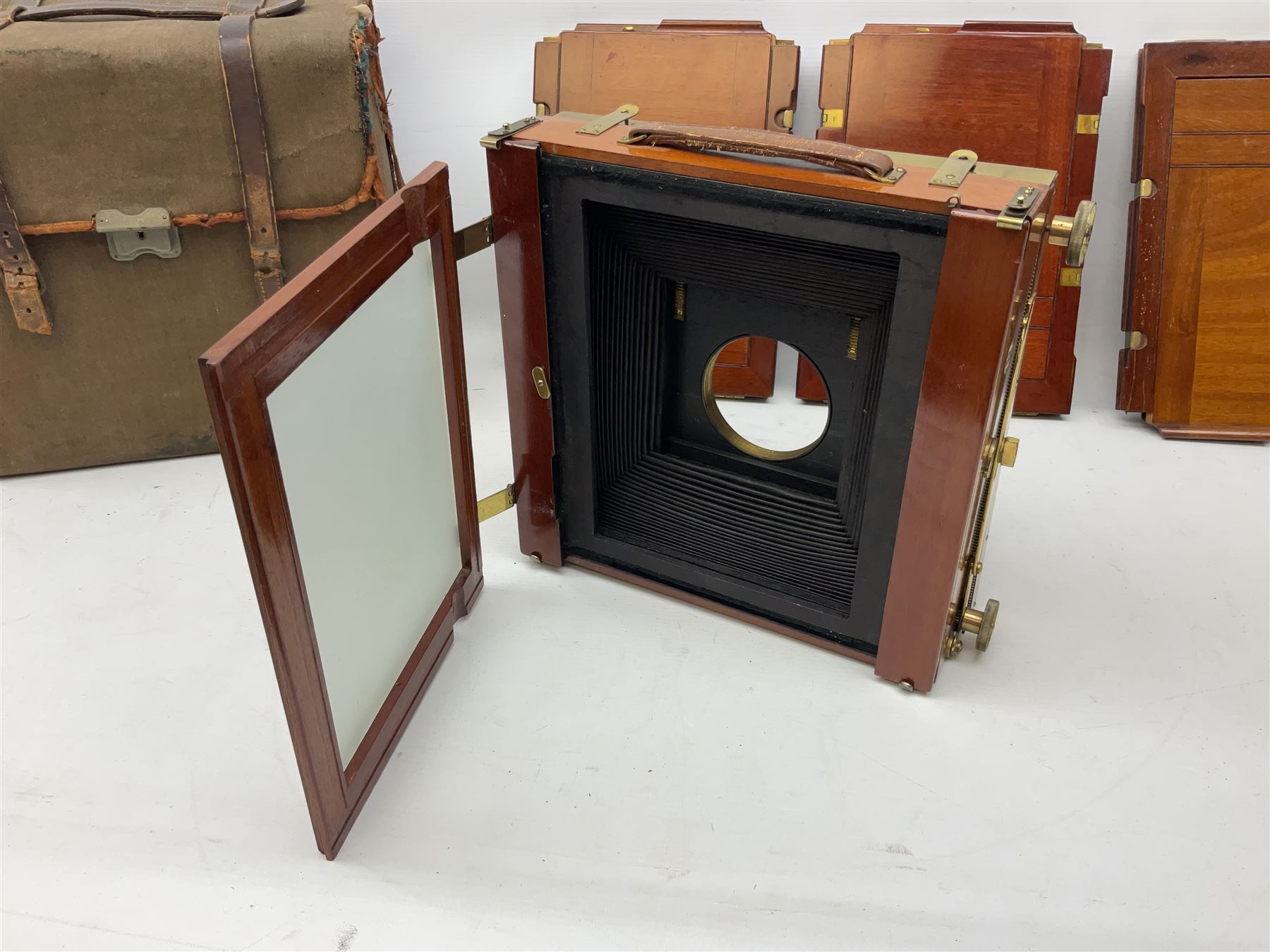 Thornton Pickard folding plate camera in mahogany and lacquered brass, no.529946 and no.529947, field model with canvas wrapped box, three mahogany photographic plates, 'Busch's Portrait Aplanat No4 Foc.14inc' lens and a wooden tripod