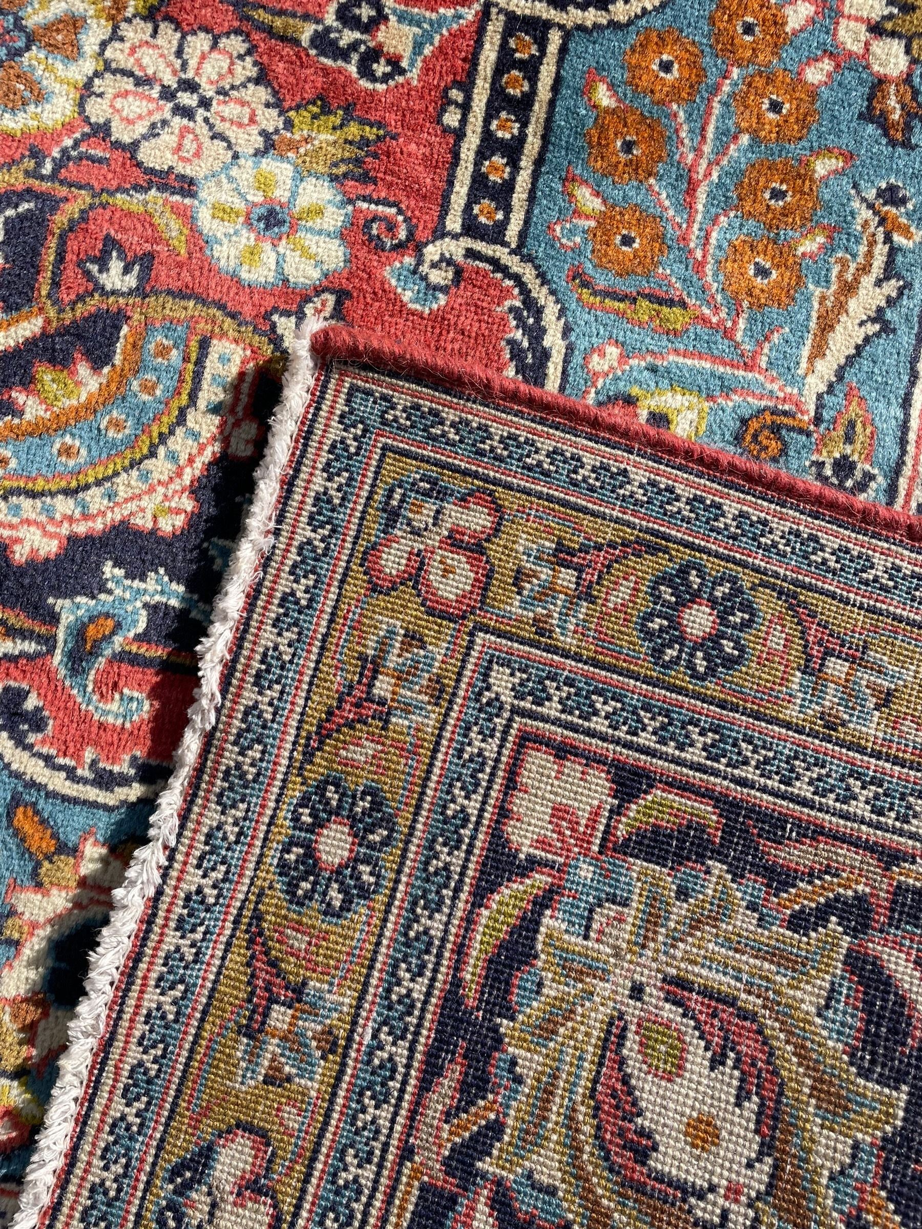 Persian Kashan peach ground rug, central rosette medallion surrounded by trailing branches and flower heads with bird motifs, light blue spandrels with further floral decoration, the main border with repeating palmettes and birds, within guard stripes