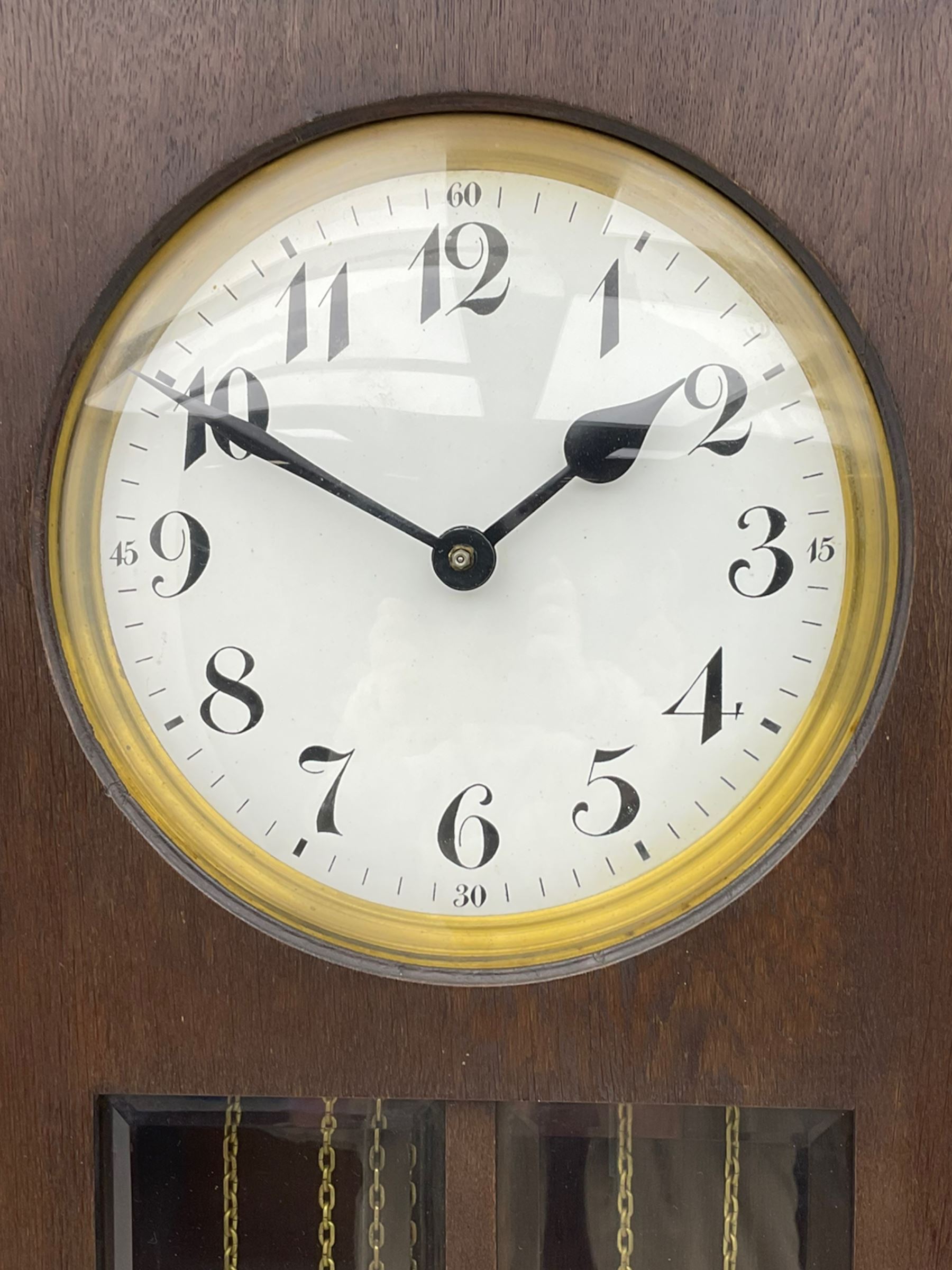 A mid-20th century weight driven floor standing clock in an oak case with canted glazed panels, full length glazed trunk door on a rectangular plinth with applied double skirting, white enamel dial with a gilt slip, upright Arabic’ numerals, minute markers, quarter hour Arabic’s and steel spade hands, with a three-train weight driven Westminster chiming movement chiming on two sets of gong rods.
With pendulum and weights.

