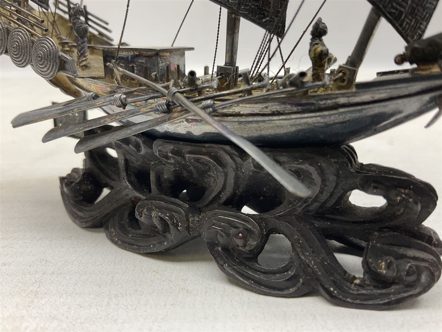 Chinese miniature silver model of a junk ship, with textured sails, mounted upon a carved wooden stand, H14cm