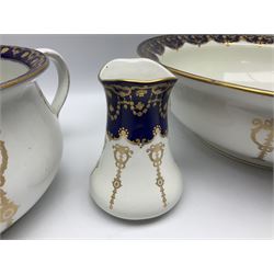 Early 20th century Bishop and Stonier four piece toilet set, comprising washbowl, wash jug, toothbrush pot, and chamber pot, each  decorated with deep blue band and husk swags and festoons in gilt, with printed Caduceus Bisto marks beneath and printed retailers mark 'Manufactured for Harrods Limited London', wash bowl D43cm, wash jug H31.5cm