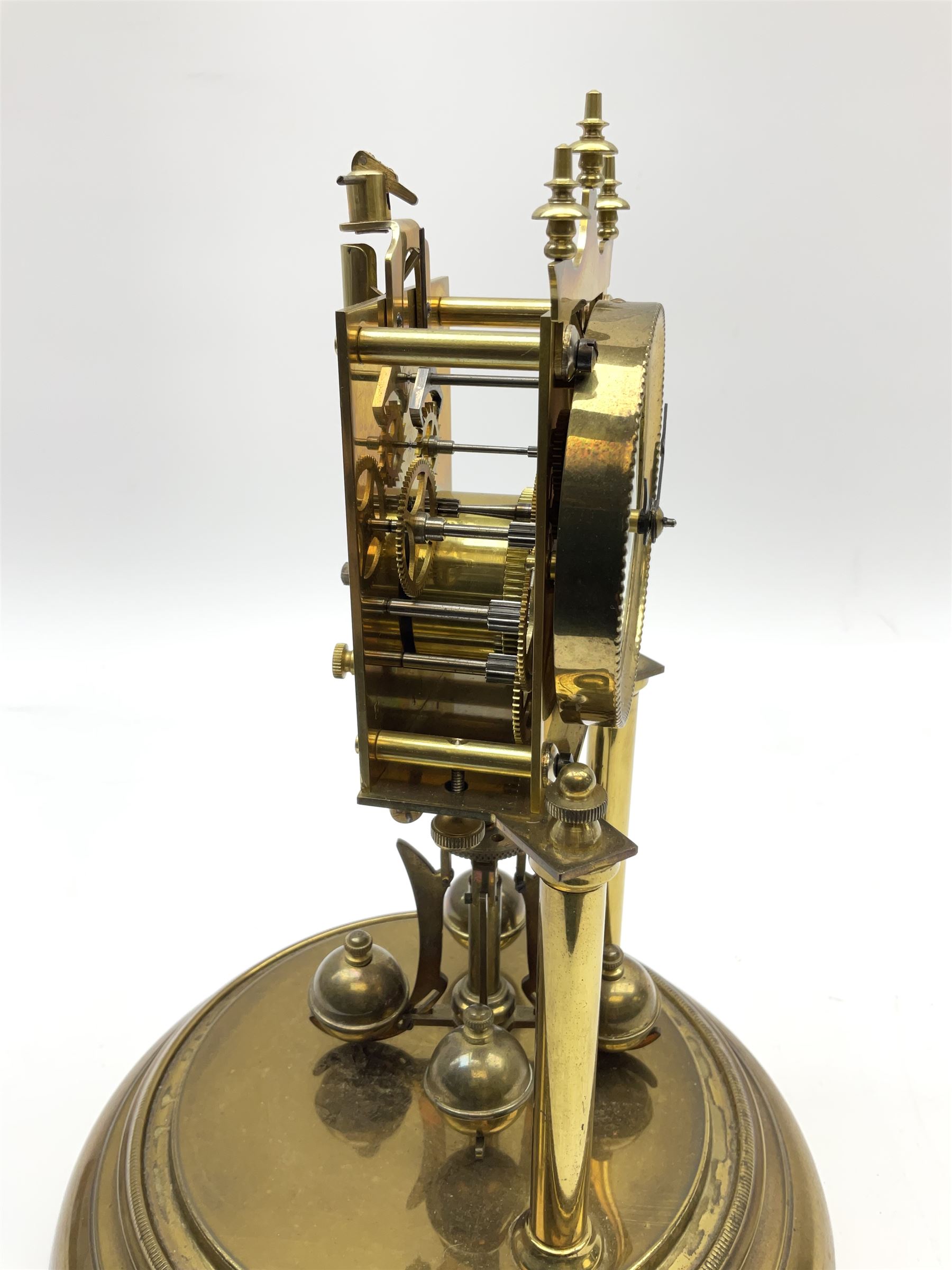 A German torsion pendulum clock by  Jahresuhrenfabrik (August Schatz & Söhne), Triberg, Germany, early 20th century with a 2-3/4-inch cream enamel dial within a spun bezel, upright Arabic numerals with minute track and steel spade hands, 400-day spring driven movement with a four-ball rotary pendulum, clear glass dome on a  20cm circular brass effect base.
Height 32cm 
