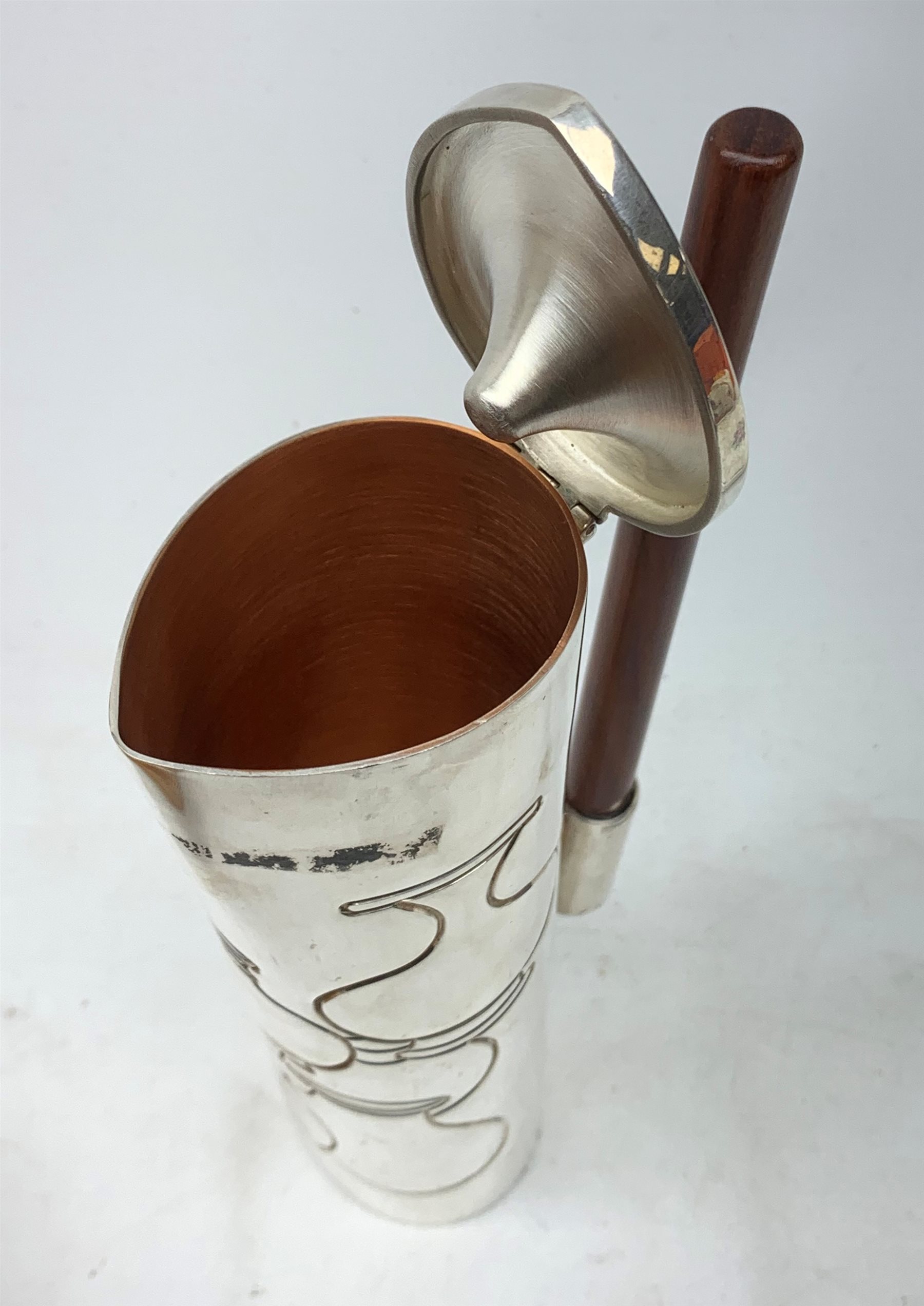 A silver plated Ravissant water jug, of cylindrical form with wooden open handle, detailed with a group of vases, marked beneath Ravissant, H25.5cm.  