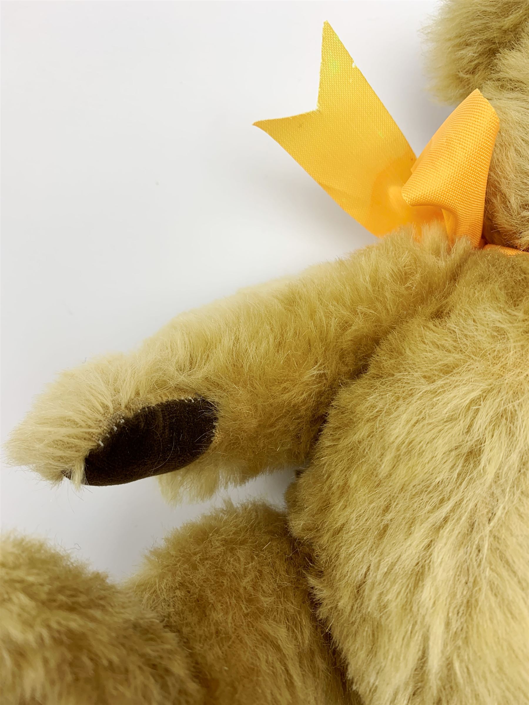 Chad Valley Hygienic Toys teddy bear c1950, kapok filled mohair plush body with original factory given yellow neck ribbon, jointed limbs with velvet paw pads, glass eyes and vertically stitched nose and mouth, blue/white printed label to side seam H12