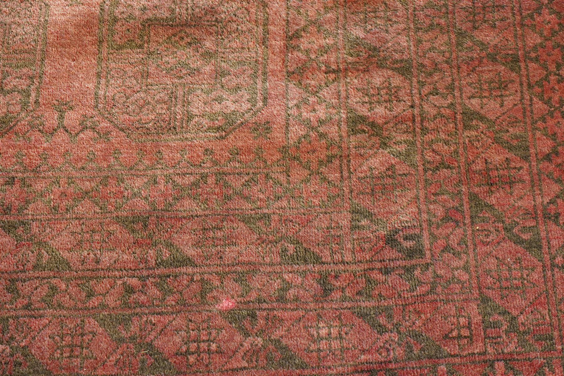 Afghan crimson ground Bokhara rug, the field with three rows of repeating Gul motifs, within six concentric guard bands decorated with repeating geometric patterns