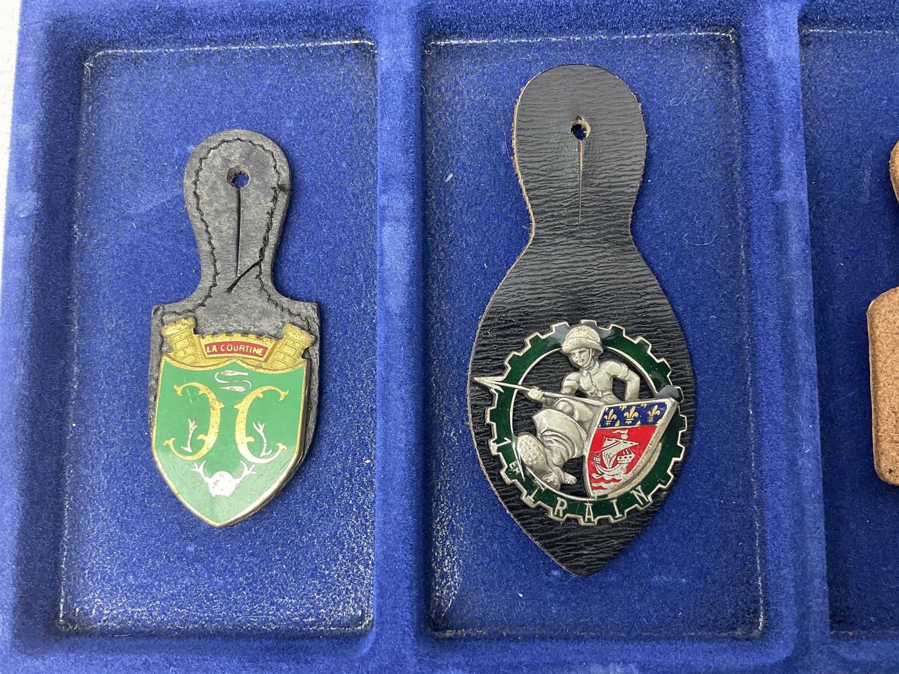 Twelve French military metal badges mounted on leather fobs including Legion, Artillery, Parachutist, Air Force, Infantry etc