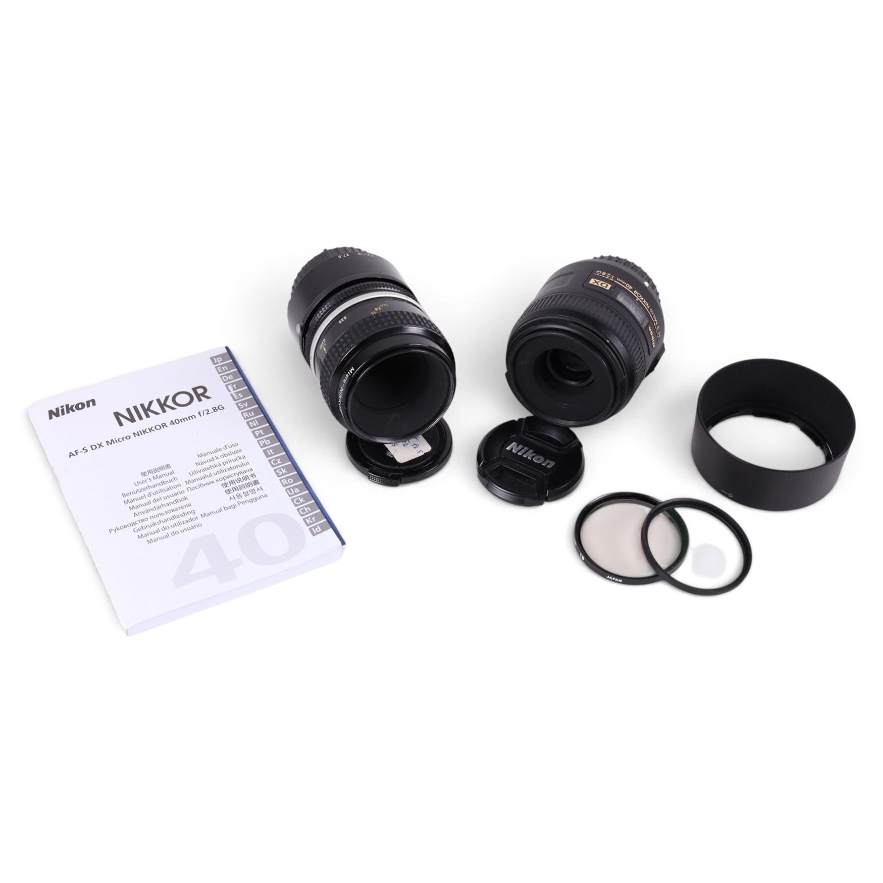 Two Micro-Nikkor camera lenses, comprising AF-S DX 40mm 1:2.8G with user manual, serial no. 2055767 and a 55mm 1:3.5 serial no. 1051782