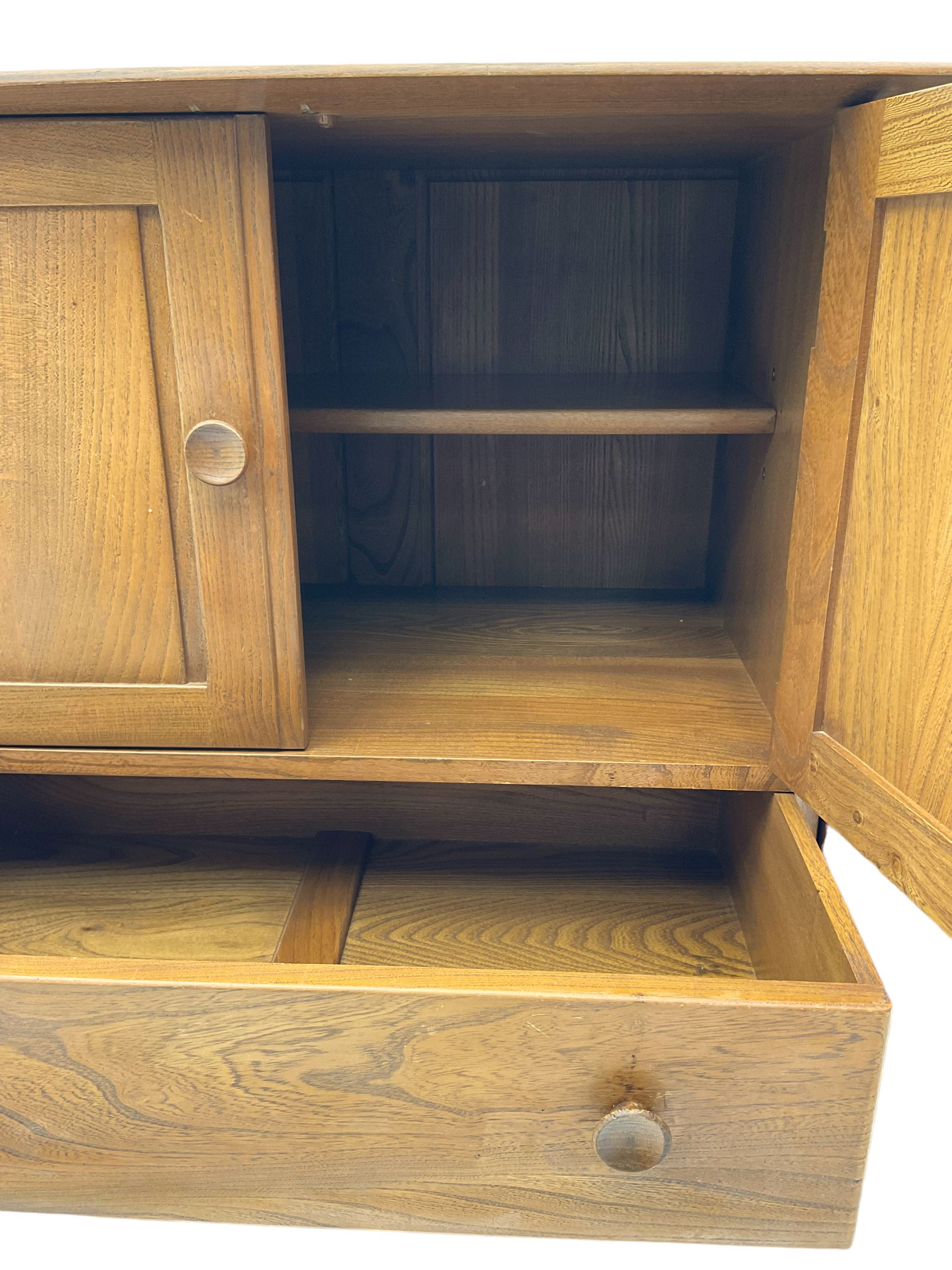 Ercol - elm and beech sideboard, fitted with cupboards and single drawer, enclosed by panelled doors, on splayed tapering feet