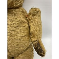 Mid-20th century plush covered teddy bear the revolving head with applied eyes, vertically stitched nose and jointed limbs with rexine pads H58cm; together with a leather backpack (2)