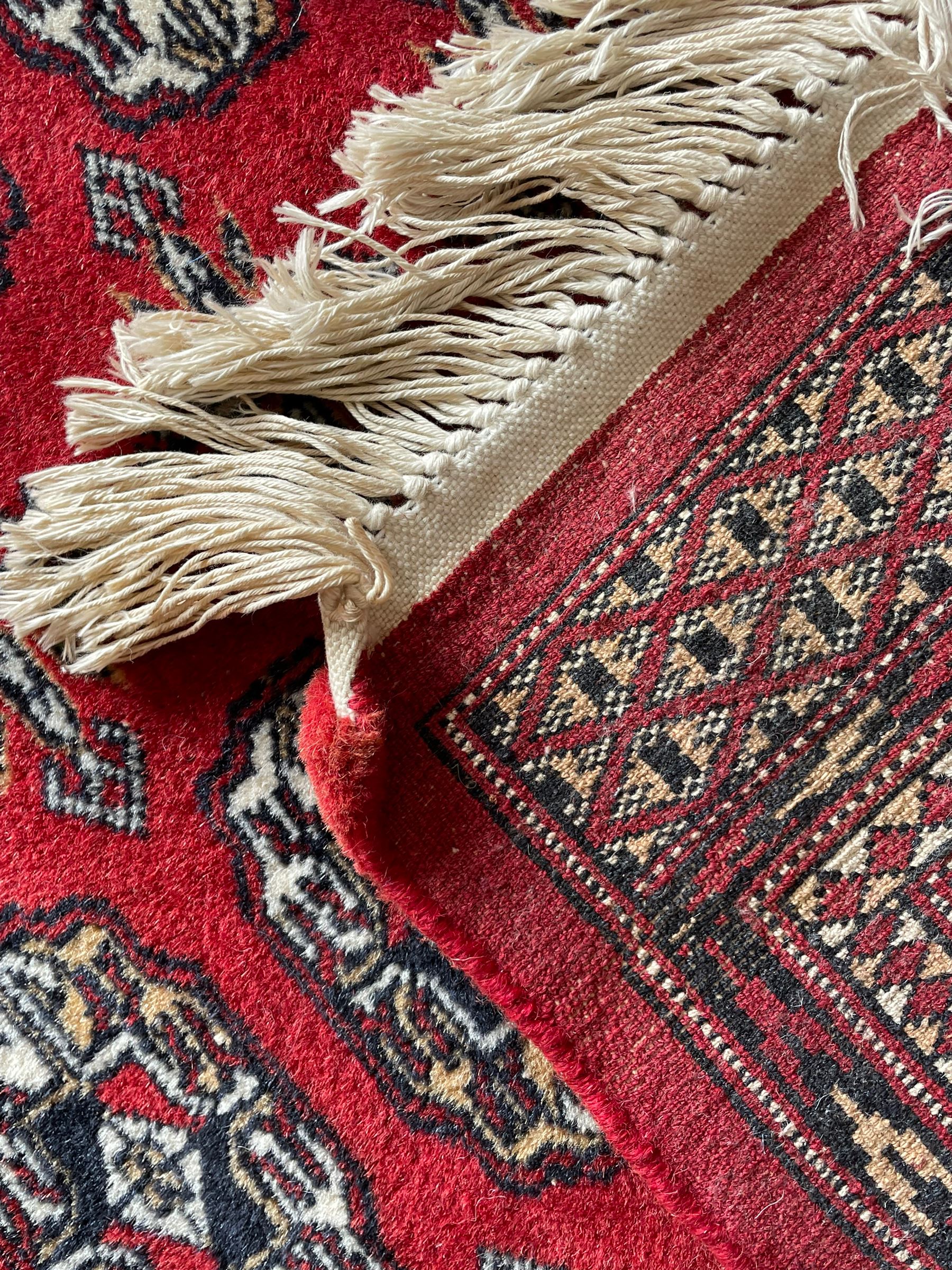 Tekke Bokhara red ground rug, decorated with two rows on Gul motifs, geometric design borders decorated with stylised floral motifs 