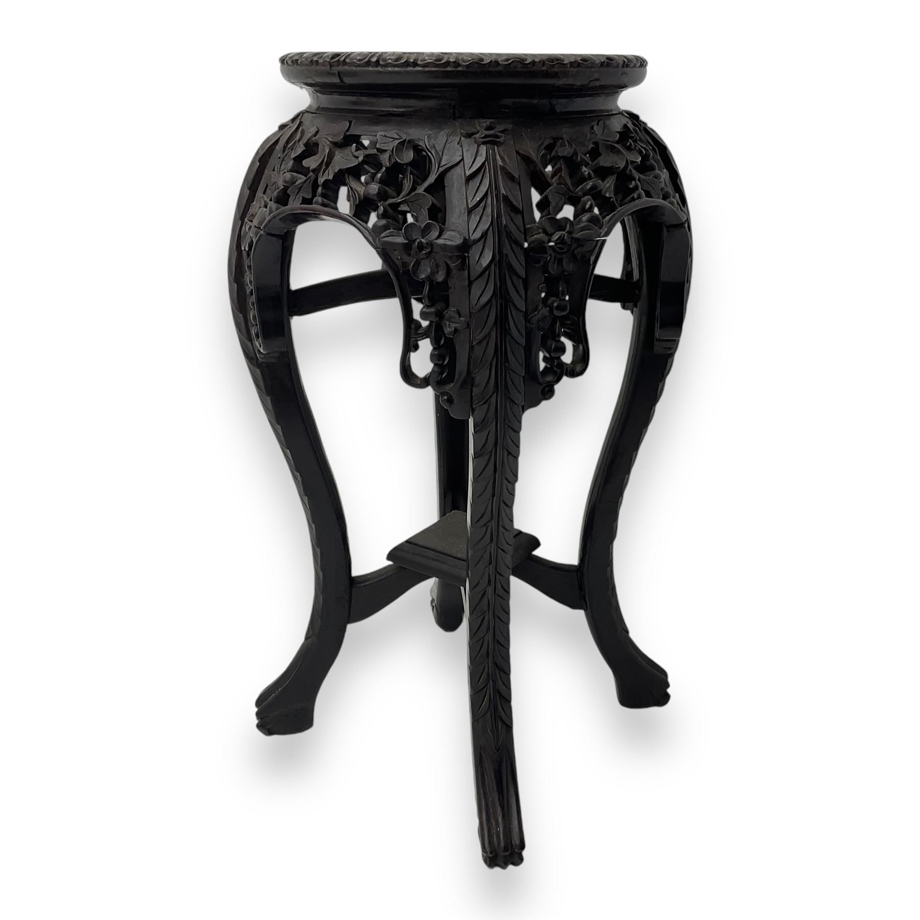 Late 19th century Chinese hardwood pedestal stand, circular top with inset marble panel, carved apron with openwork foliate and floral motifs, raised on cabriole supports with stylised claw and ball feet united by square undertier