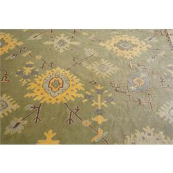 Lage Turkish Oushak green ground carpet, the field decorated with large stylised plant motifs and geometric design, the sage green guard band with further repeating foliate motifs