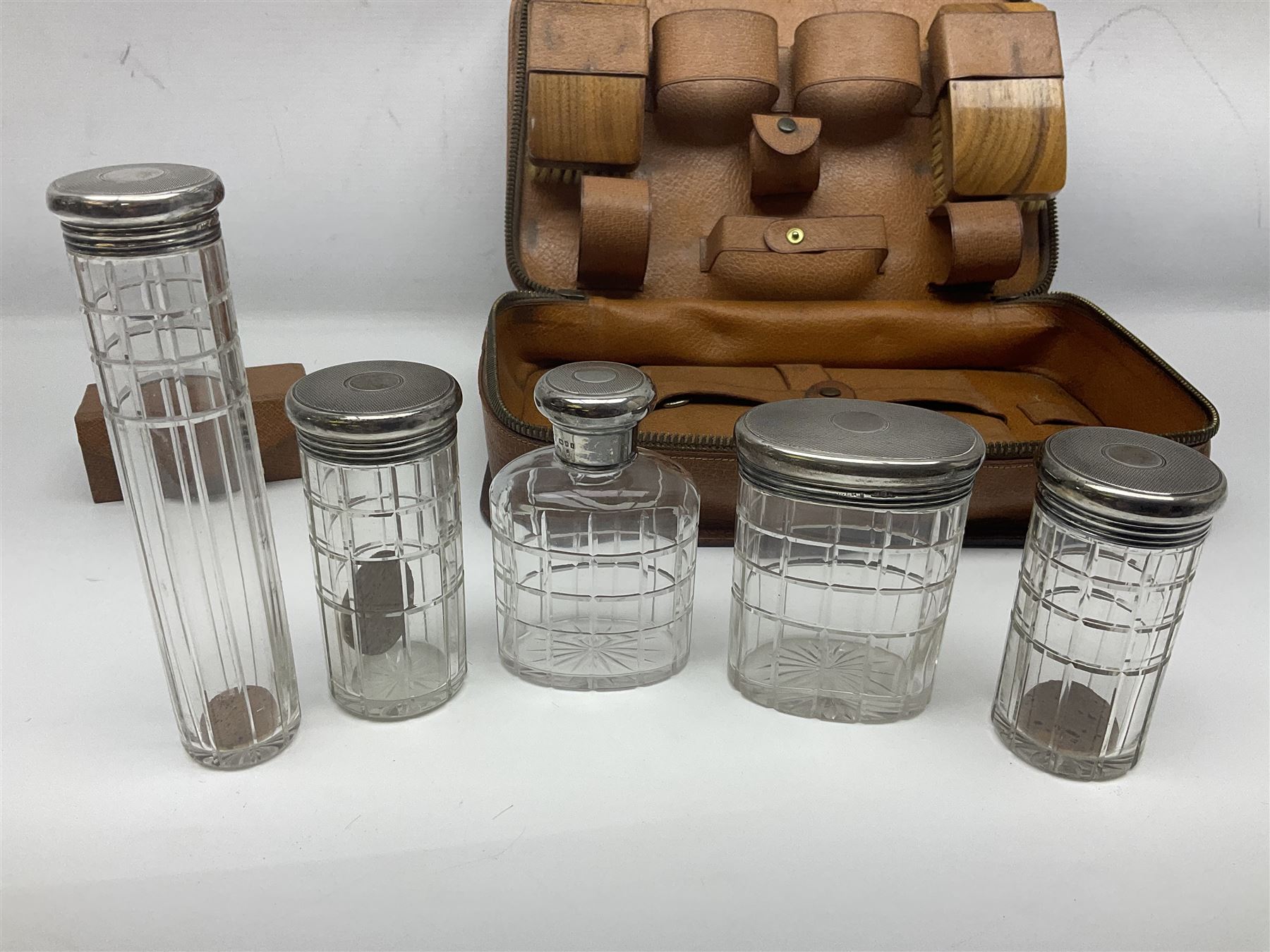 Mappin & Webb leather cased campaign gentleman's vanity set, the tan leather case opening to reveal fitted interior with five engine turned silver capped glass vanity bottles, hallmarked Mappin & Webb, London 1944, brushes, mirror etc, monogram DPK to the top of the case