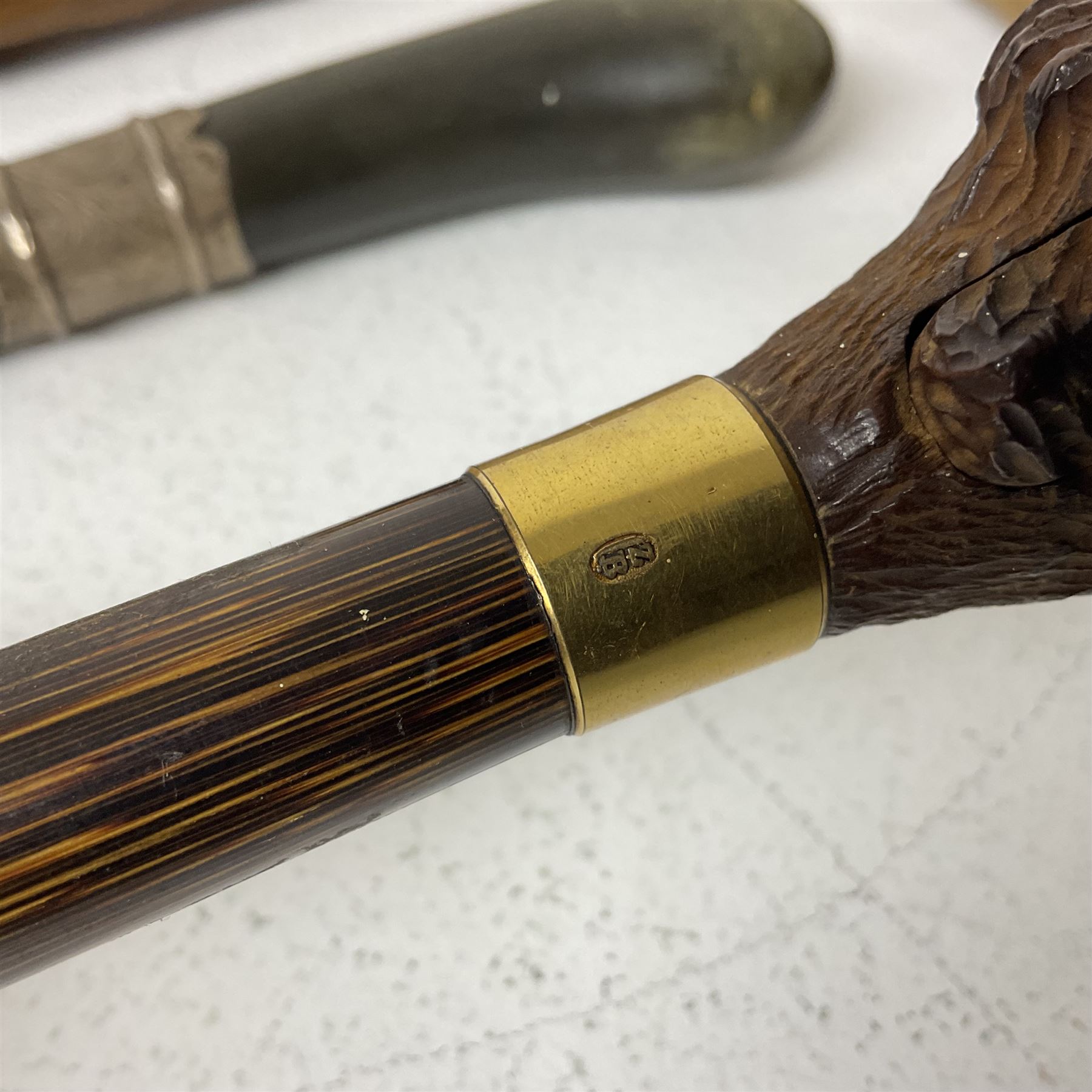 19th century painted bamboo walking cane, the handle carved as a fox with glass eyes, with gilt metal stamped LB, together with an ebonised wooden walking stick, with horn pommel and hallmarked silver collar and a curved wooden walking stick, with monogrammed white metal cap, tallest L90cm