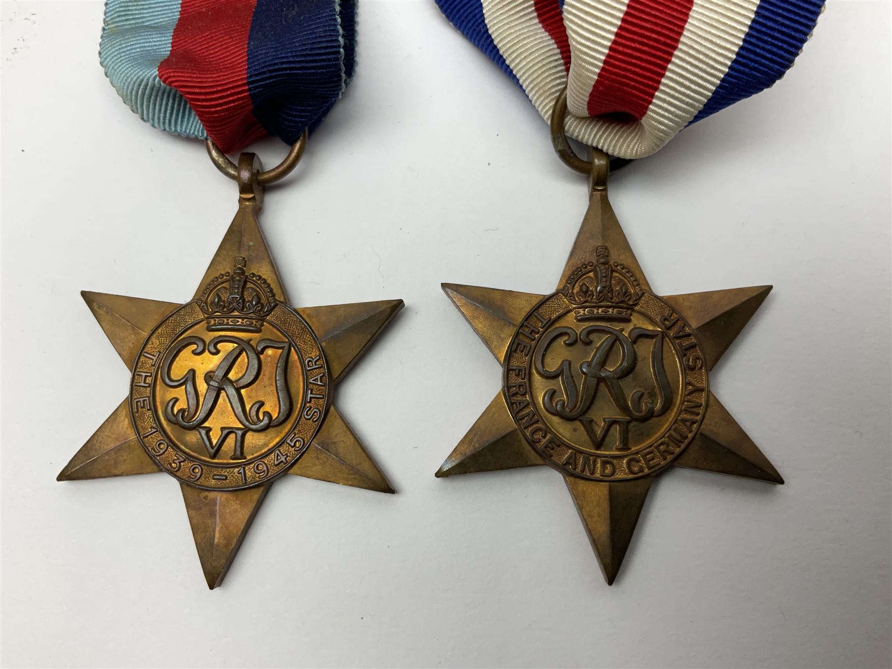 WW1 pair of medals awarded to 151761 Gnr. S. Loten R.A. with ribbons; four WW2 medals with ribbons; and small quantity of cap badges, medallions etc