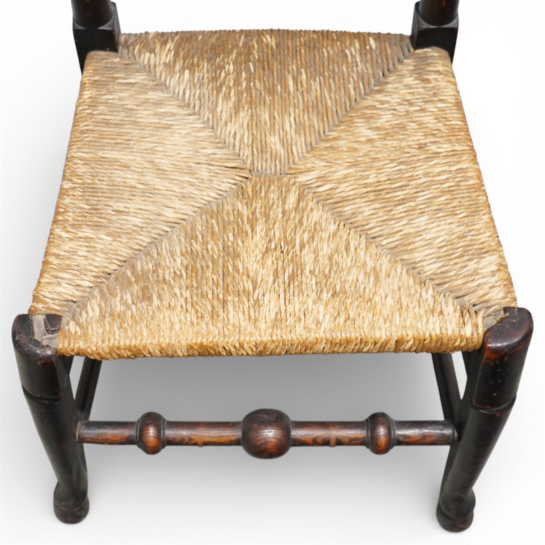 Set of five 19th century elm spindle back chairs, with shaped crest rails above double rows of turned spindles, rush seats, turned legs joined by stretchers supported on turned pad feet