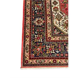 North West Persian pink ground Tabriz carpet, central indigo ground medallion surrounded by stylised plant motifs and trailing foliage, the main border with overall floral design within guard stripes 