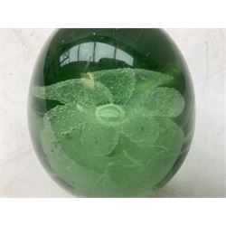 Pair of Victorian green glass dump paperweights with interior flower decoration, and another example with internal air bubble inclusions, tallest example H16cm