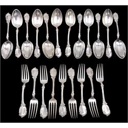 Early 20th century Danish silver flatware, comprising set of twelve table spoons and nine table forks, each embossed with scroll, foliate and floral decoration to handles, and engraved with monogram to terminals, with three-tower mark and dated 1904, maker's mark AM, assayer Christian F Heise