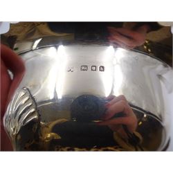 1920s three piece silver tea service, comprising teapot, with ebonised wooden handle and finial, milk jug and open sucrier, all of circular form, with shaped rims, and upon three hoof feet, hallmarked Wakely & Wheeler, London 1922, teapot H19cm