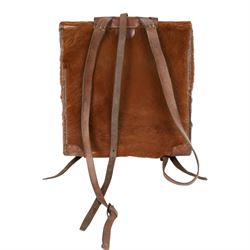Swiss army pony skin backpack, with rolled leather edges and leather straps, the back straps stamped with Swiss cross over Sch., the fascia enclosing two belted flaps, with cream canvas lining, H38cm, W37cm