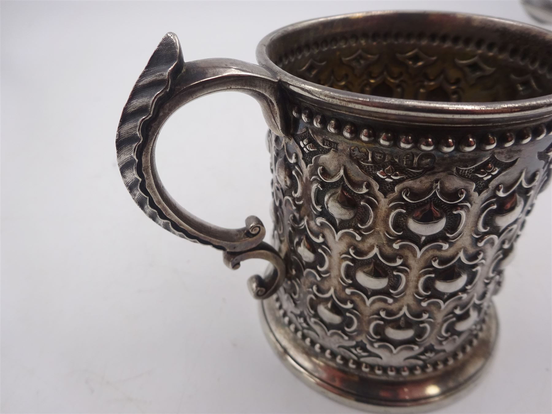 Victorian silver christening mug, with repousse and chased scroll and bead decoration, lozenge shaped cartouche engraved with monogrammed initials and acanthus capped C scroll handle, hallmarked Robert Hennell III, London 1861, H9.3cm