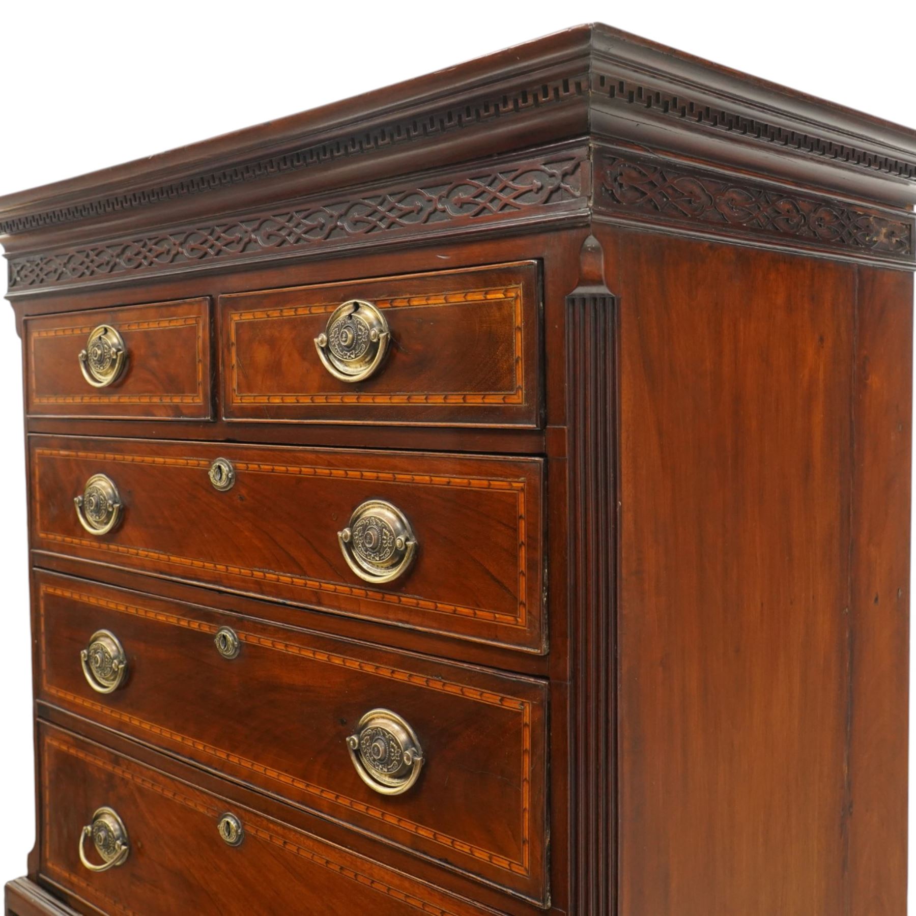  Late 18th century mahogany and inlaid chest on chest, projecting cornice above blind fretwork in laid drawers, the upper chest with two short over three graduating drawers, the lower section with brushing slide over three long graduated drawers, raised on bracket feet