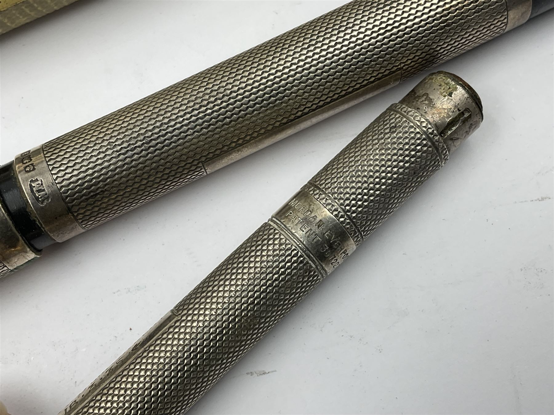 Three parker fountain pens, one example with 14ct gold plated cap and personal engraving, in Parker 51 box, together with a silver Sampson Mordan Everpoint propelling pencil with personal engraving and a silver cased fountain pen with 14ct gold nib and a souvenir bronze Dollfus-Mieg medallion, awarded to John G Sedorski, in fitted case 