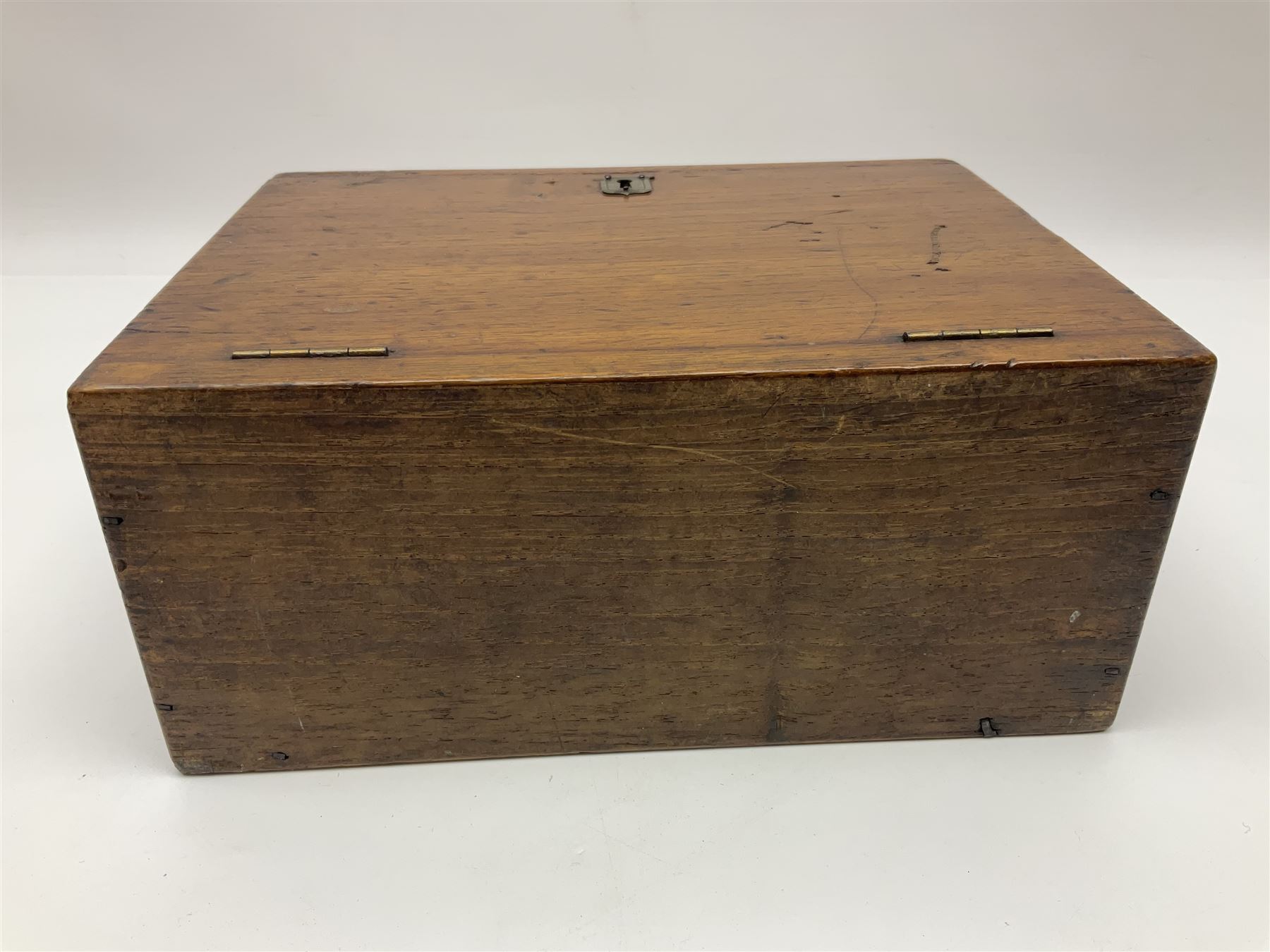 Wooden table stationery box, with drop down front and fitted interior, with metal shield plaque to the hinged lid, H18cm