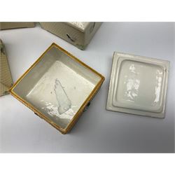 Four square honey boxes with lids,  each decorated with honeycomb pattern and finished with a bee finial