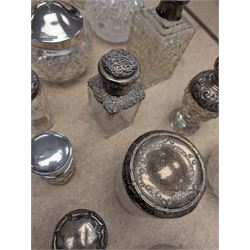 Collection of silver mounted glass bottles and jars, including decanter with etched floral decoration and silver collar, four scent bottles with silver caps, etc all hallmarked 