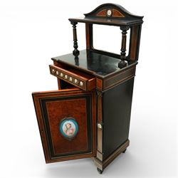 Victorian Aesthetic Movement amboyna and ebonised cabinet, the arched raised back inlaid with amboyna and floral porcelain plaque, over a raised shelf with fluted and turned supports, and a bevelled mirror plate with brass beading beneath, the inverted-breakfront top over an ornate frieze drawer with guilloche style gilt-metal mounts and porcelain plaques, the panelled door with a central porcelain plaque depicting a lady in a fuchsia gown within concentric ebonised and amboyna inlays, flanked by architectural style uprights with Corinthian capitals, raised on turned feet