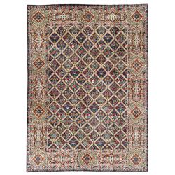 Persian Kirman indigo ground carpet, the field with repeating lozenge tiles with overall floral decoration, the main border with floral panels enclosed by the guards