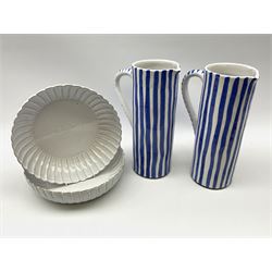 A pair of large pottery jugs with decorated with blue vertical stripes upon a white ground, each H31.5cm, together with a pair of white glazed and part fluted potter bowls, D27cm. 
