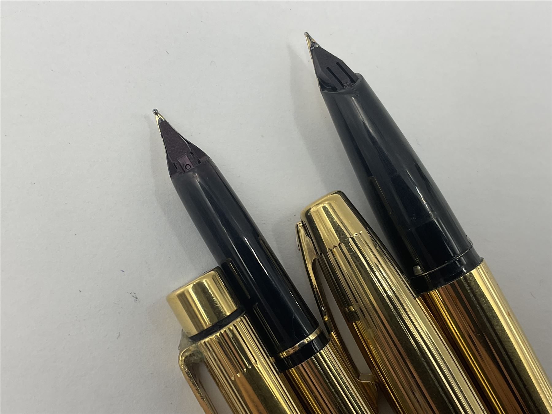 Sheaffer Triumph Imperial fountain pen, the gold plated barrel with fluted stripe design and gold nib stamped 14K 585, together with a Sheaffer Targa slimline fountain pen with gold plated barrel similarly decorated with gold nib stamped 14K 585, ballpoint pen and propelling pencil, each with a fluted gold plated barrel, largest L13.5cm (4)